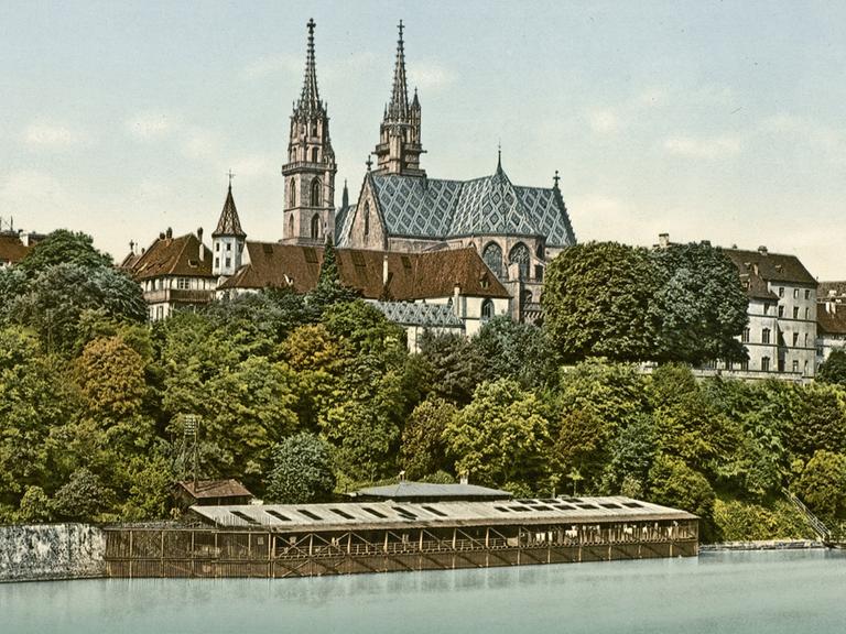 Die Badeanstalt Pfalzbadhysli am Rhein und das Münster in Basel in der Schweiz, aufgenommen um 1900.