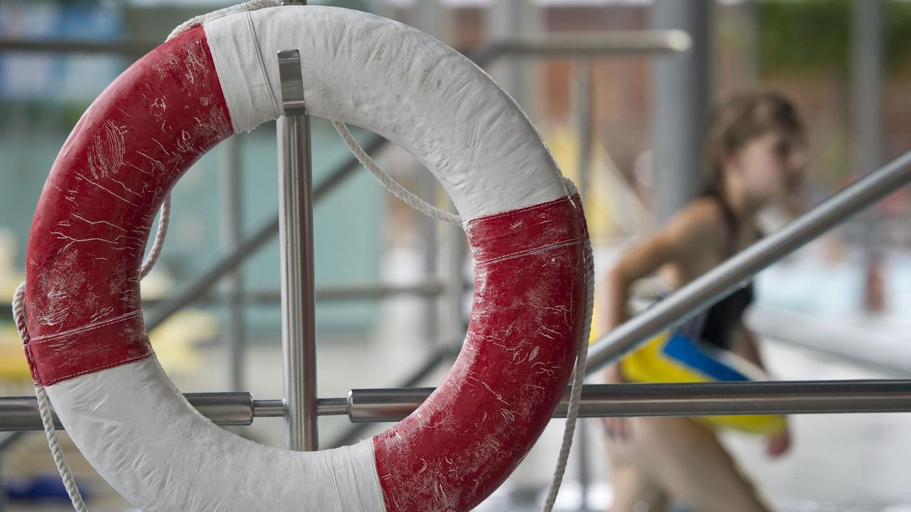 Ein Kind mit Schwimmring geht im Geibeltbad in Pirna (Sachsen) an einem Rettungsring vorbei.