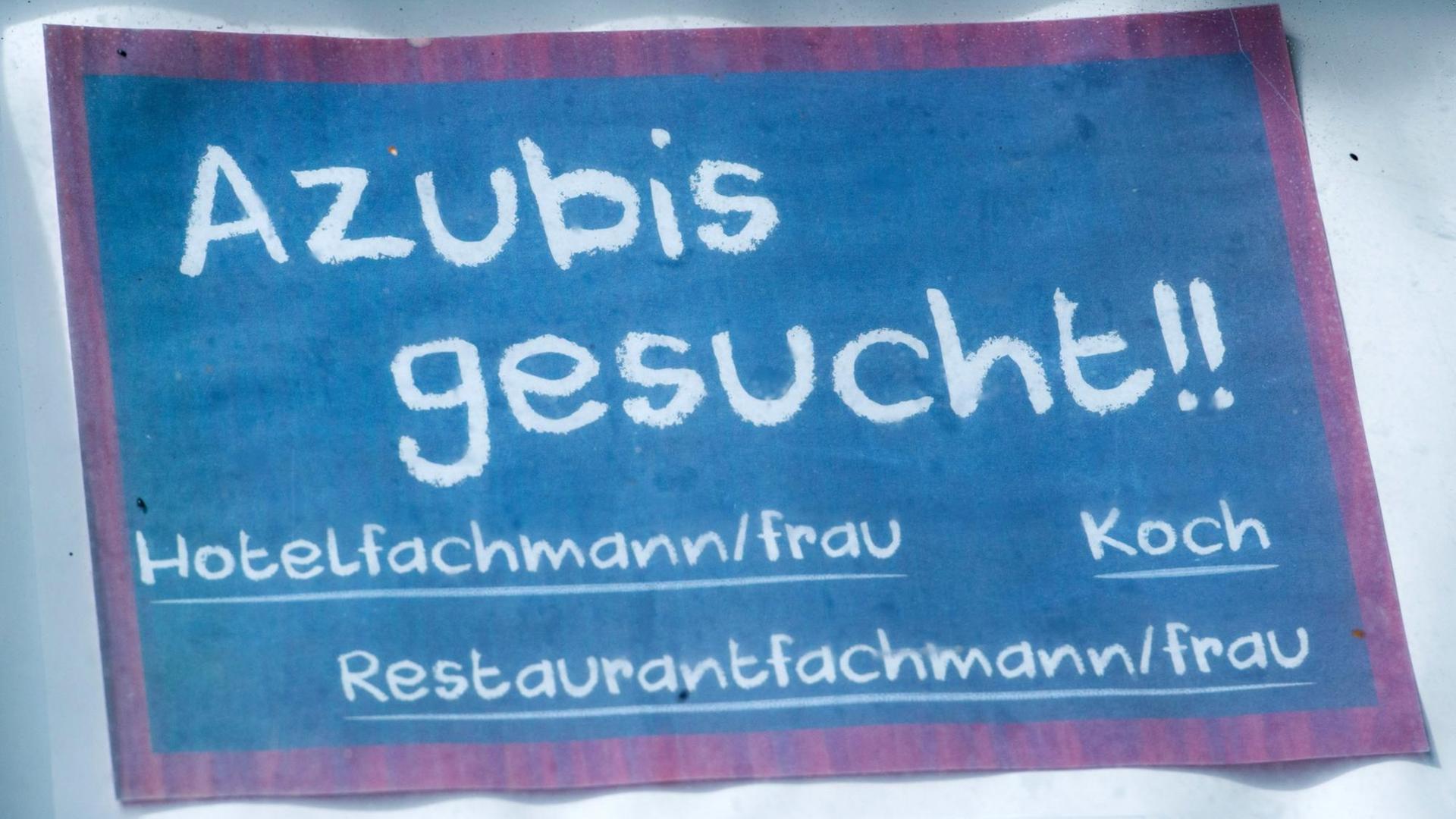 Vor einem Hotel hängt ein Schild mit dem Schriftzug "Azubis gesucht !!"