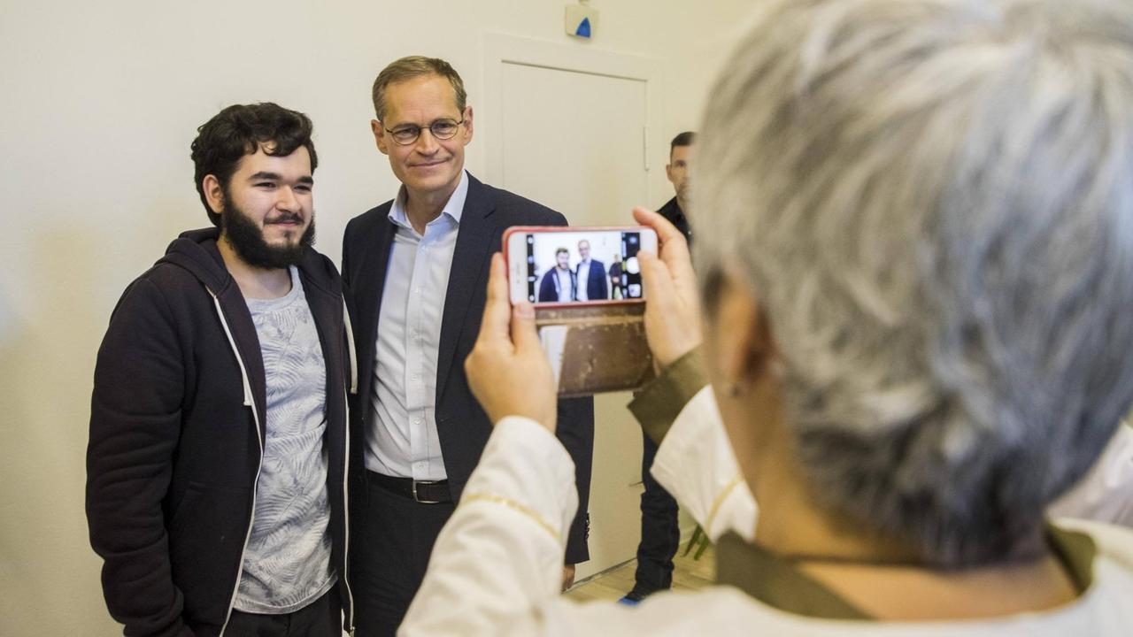 Tugay Sarac posiert für ein Foto mit dem Berliner Bürgermeister Michael Müller.