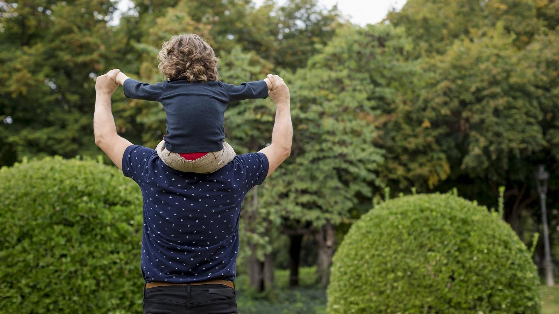 Ein Sohn sitzt auf den Schultern seines Vaters - Symbolfoto