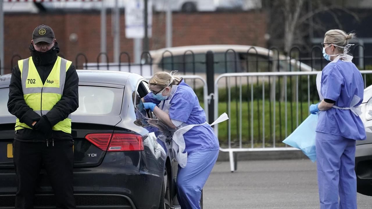 Das Foto zeigt ein Coronavirus-Testgelände, das auf einem Parkplatz in Wolverhampton, England, eingerichtet wurde, während ein Abstrich einer Person in einem KFZ durch Mitarbeiterinnen des Nationalen Gesundheitsdienstes (National Health Service) genommen wird.