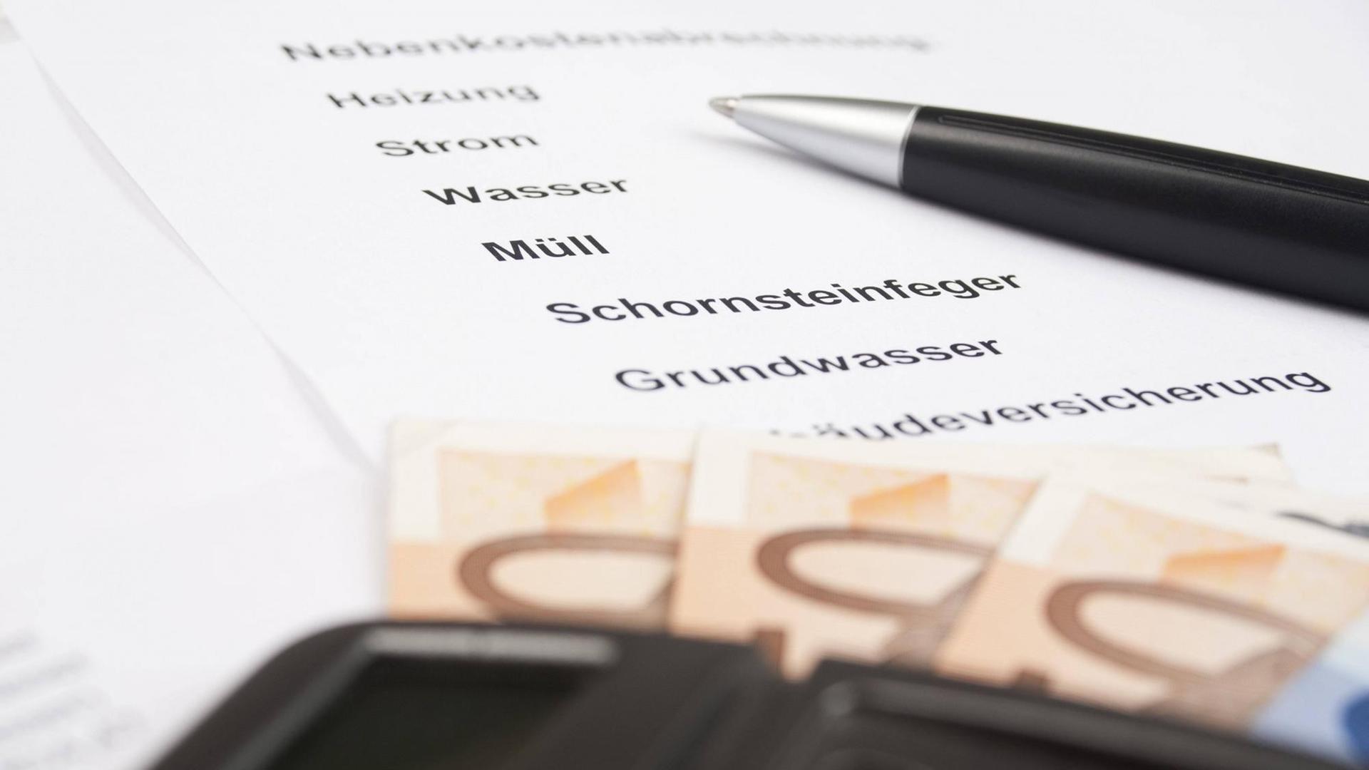 Nebenkostenabrechnung mit Kugelschreiber und Taschenrechner Nebenkostenabrechnung mit Kugelschreiber und Taschenrechner