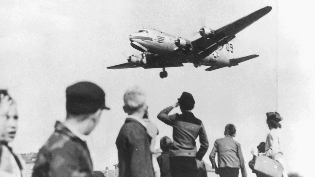 Kinder warten auf das Flugzeug von US-Leutnant Halversen, der die Taschentuchfallschirme mit Süßigkeiten abzuwerfen pflegt, aufgenommen am 30.9.1948.