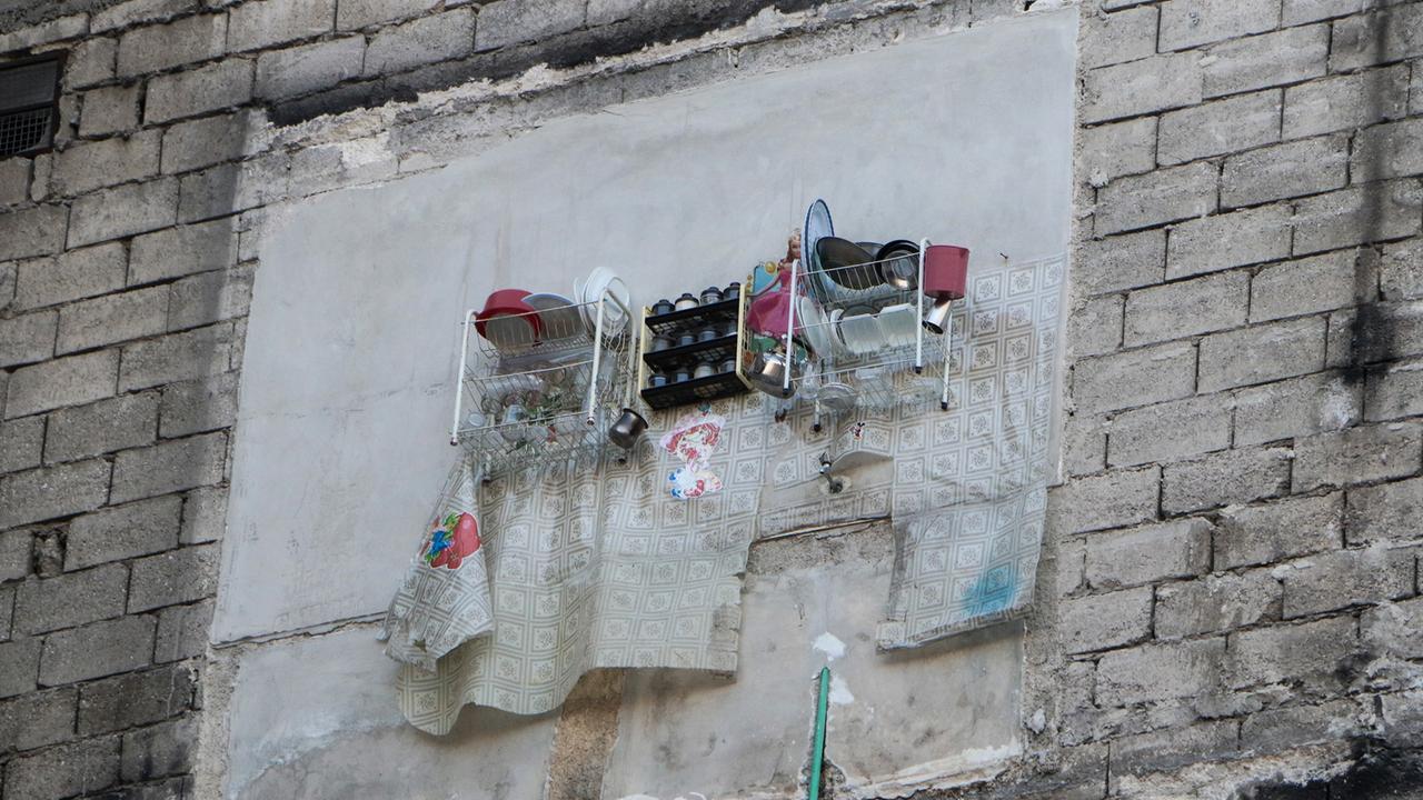 Geschirr ist von außen in einem zerstörten Haus in Aleppo zu sehen.