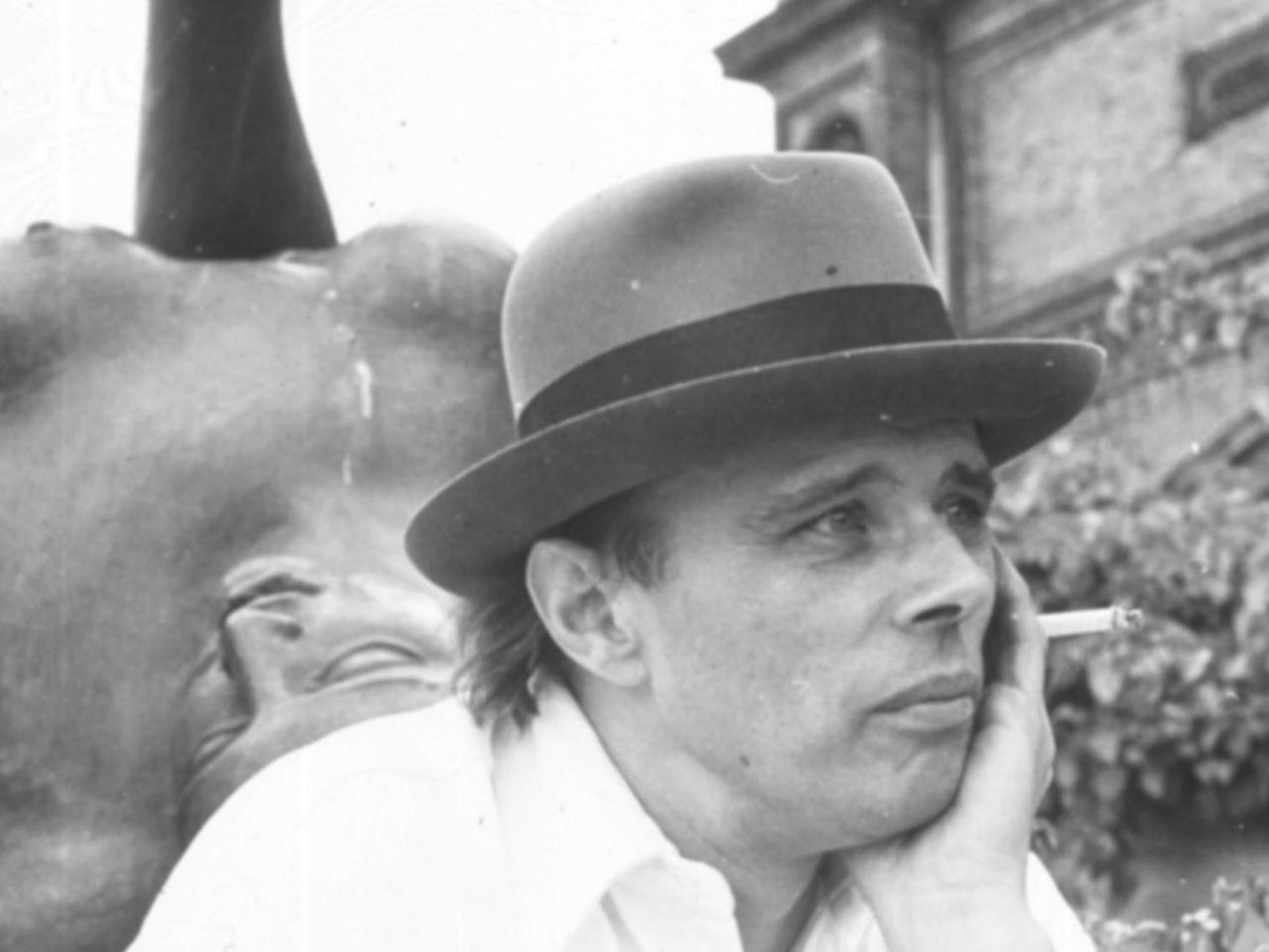 Joseph Beuys sitzt vor der Bleiplastik „Der Fluss“ von Aristide Maillol vor der Hamburger Kunsthalle und raucht eine Zigarette