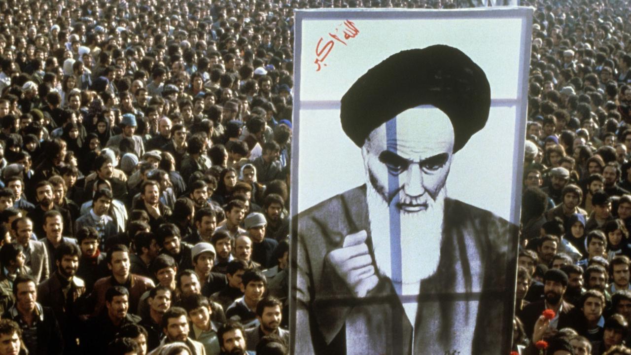 Demonstranten mit einem überdimensionalen Bild des Revolutionsführers Ayatollah Khomeini während einer Anti-Schah-Demonstration in Teheran.