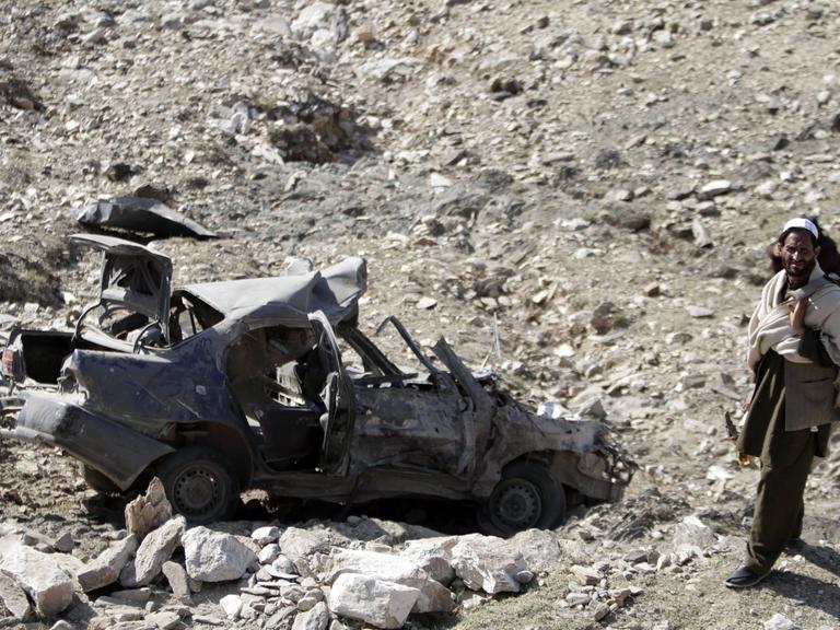 Afghanischer Mann untersucht eine Stelle, an der eine Autobombe explodiert ist (28.11.2013)