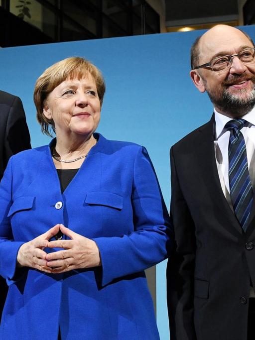 Der CSU-Vorsitzenden Horst Seehofer (l), der SPD-Parteivorsitzende Martin Schulz (r) und Bundeskanzlerin Angela Merkel (CDU) stellen sich am 12.01.2018 im Willy-Brandt-Haus in Berlin nach einer Pressekonferenz zu einem Foto auf. Die Spitzen von CDU, CSU und SPD streben eine Neuauflage der großen Koalition an.