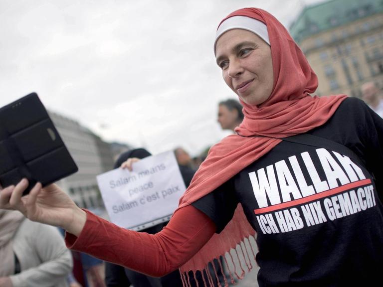 Eine Frau mit Kopftuch und einem T-shirt mit der Aufschrift "Wallah Ich hab nix gemacht" auf dem Friedensmarsch von Muslimen und muslimischen Verbänden in Berlin.