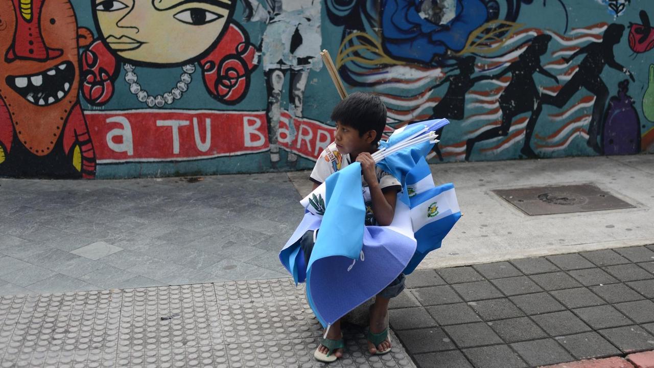Ein Junge verkauft Flaggen von Guatemala in der Hauptstadt.