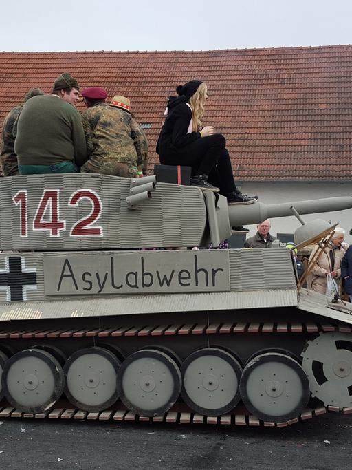 Ein Panzer mit der Aufschrift "Ilmtaler Asylabwehr" nimmt am 7. Februar 2016 an einem Faschingsumzug in Reichertshausen im Landkreis Pfaffenhofen in Bayern teil Die Behörden ermitteln nun wegen des Verdachts der Volksverhetzung.