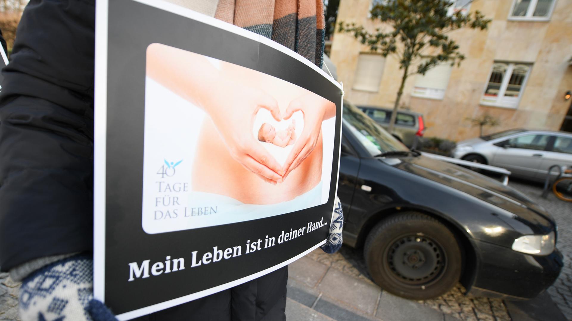 Mit einem Plakat mit der Aufschrift "Mein Leben ist in deiner Hand..." demonstriert eine Abtreibungsgegnerin von der "Aktion SOS Leben" vor der Beratungsstelle von Pro Familia in Frankfurt am Main.