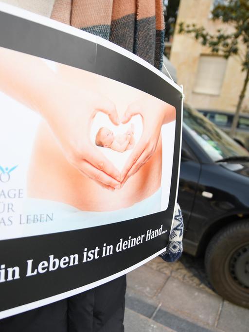 Mit einem Plakat mit der Aufschrift "Mein Leben ist in deiner Hand..." demonstriert eine Abtreibungsgegnerin von der "Aktion SOS Leben" vor der Beratungsstelle von Pro Familia in Frankfurt am Main.