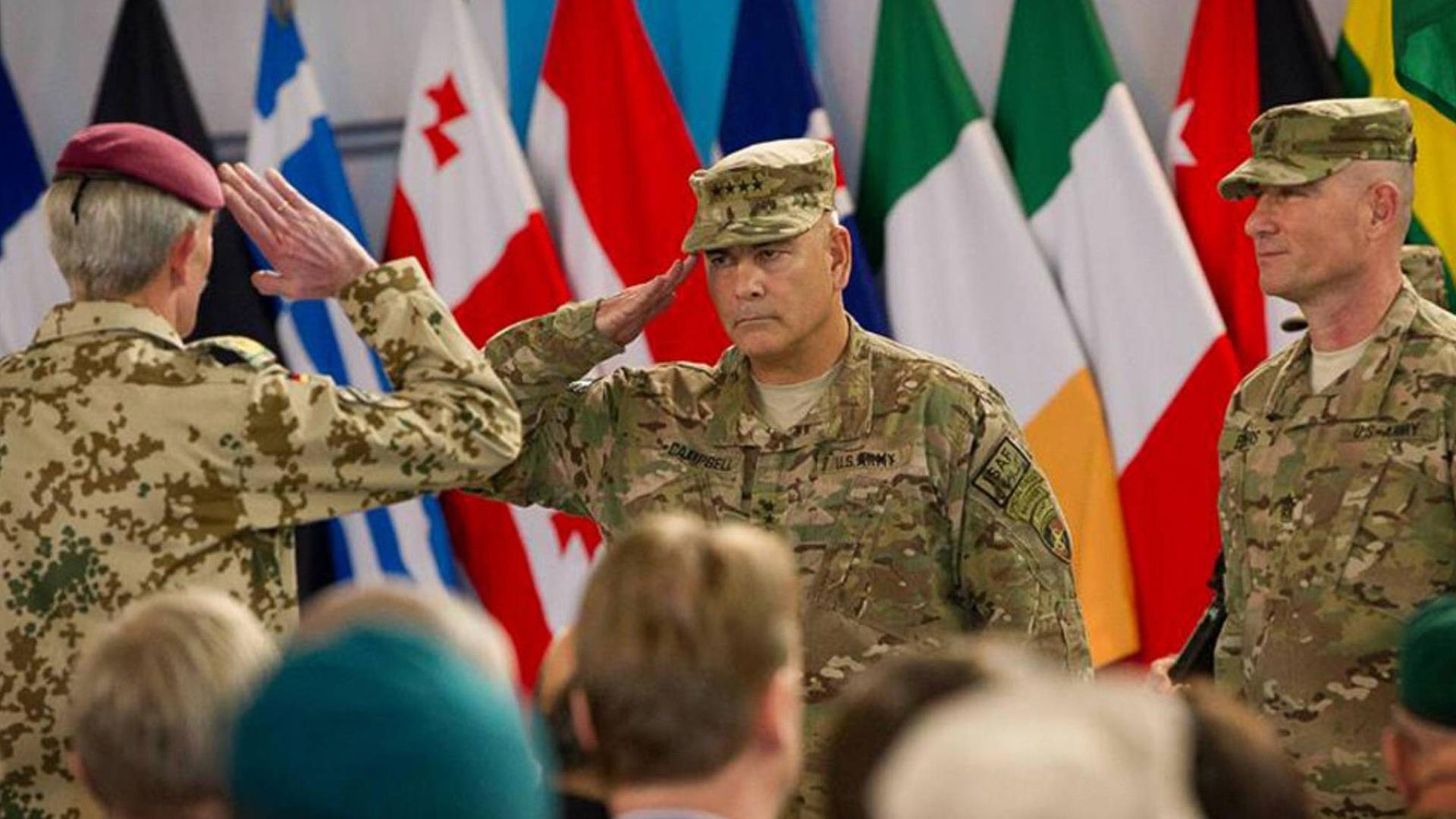 Der US-Kommandant der Nato-geführten Internationalen Afghanistan-Schutztruppe ISAF, General John F. Campbell (m.), salutiert während einer Zeremonie in der Hauptstadt Kabul, die das Ende des Kampfeinsatzes der ISAF markiert.