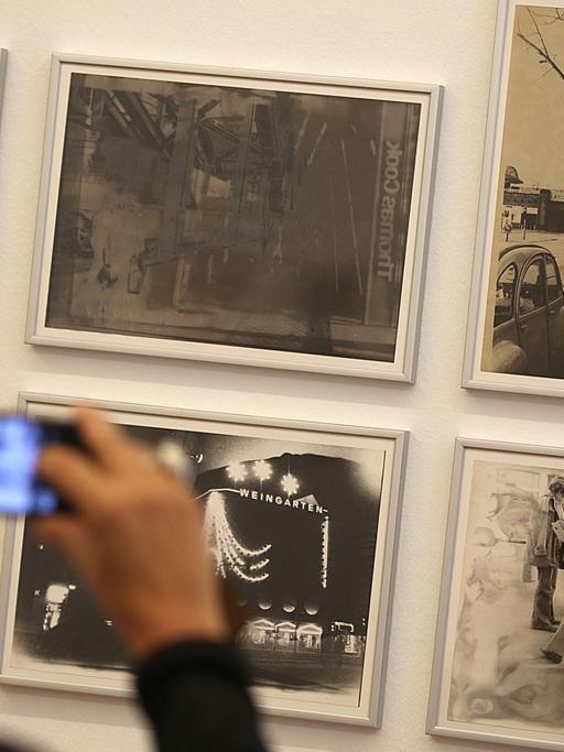 Eine Frau hält ihr Smartphone vor Fotografien aus der Serie «Köln» von Sigmar Polke. Die Ausstellung «Fotografien 70 - 80» von Sigmar Polke ist vom 27. Mai 2018 - 02. September 2018 im Museum Morsbroich zu sehen.