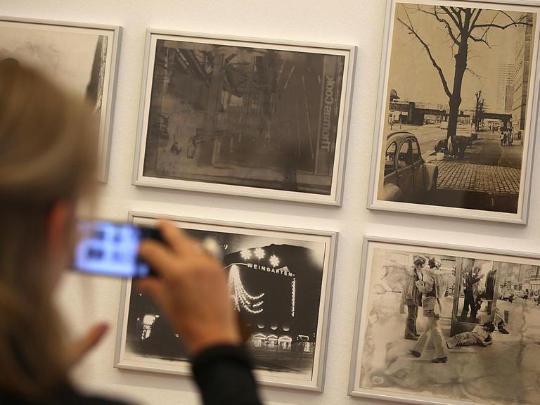 Eine Frau hält ihr Smartphone vor Fotografien aus der Serie «Köln» von Sigmar Polke. Die Ausstellung «Fotografien 70 - 80» von Sigmar Polke ist vom 27. Mai 2018 - 02. September 2018 im Museum Morsbroich zu sehen.