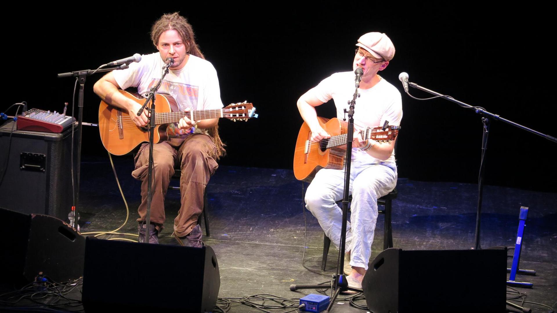 Die beiden Musiker des Duos Simon&Jan sitzen auf der Bühne mit ihren Gitarren und singen