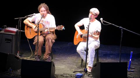 Die beiden Musiker des Duos Simon&Jan sitzen auf der Bühne mit ihren Gitarren und singen