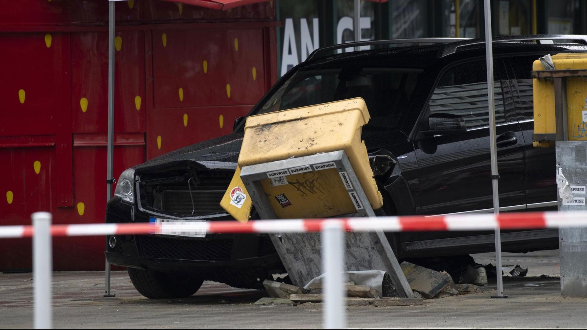 Ein Auto steht nach dem Zusammenstoß mit einer Menschengruppe am Hardenbergplatz an einem zerstörten Briefkasten.