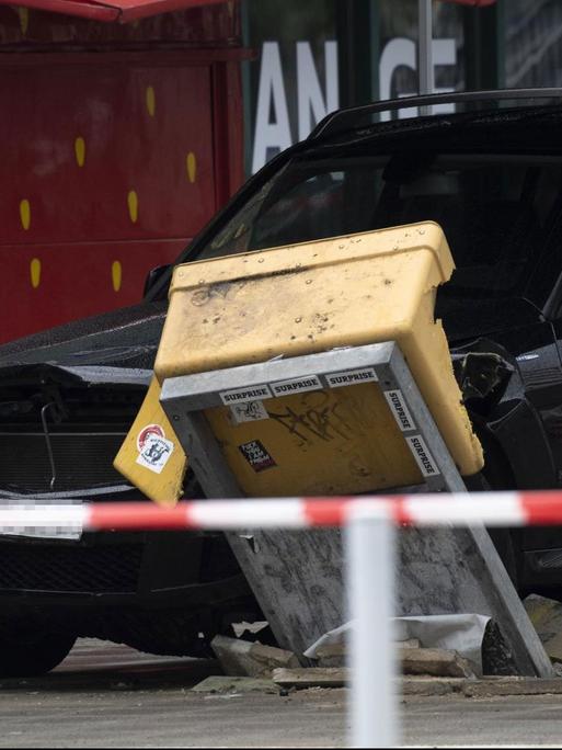 Ein Auto steht nach dem Zusammenstoß mit einer Menschengruppe am Hardenbergplatz an einem zerstörten Briefkasten.