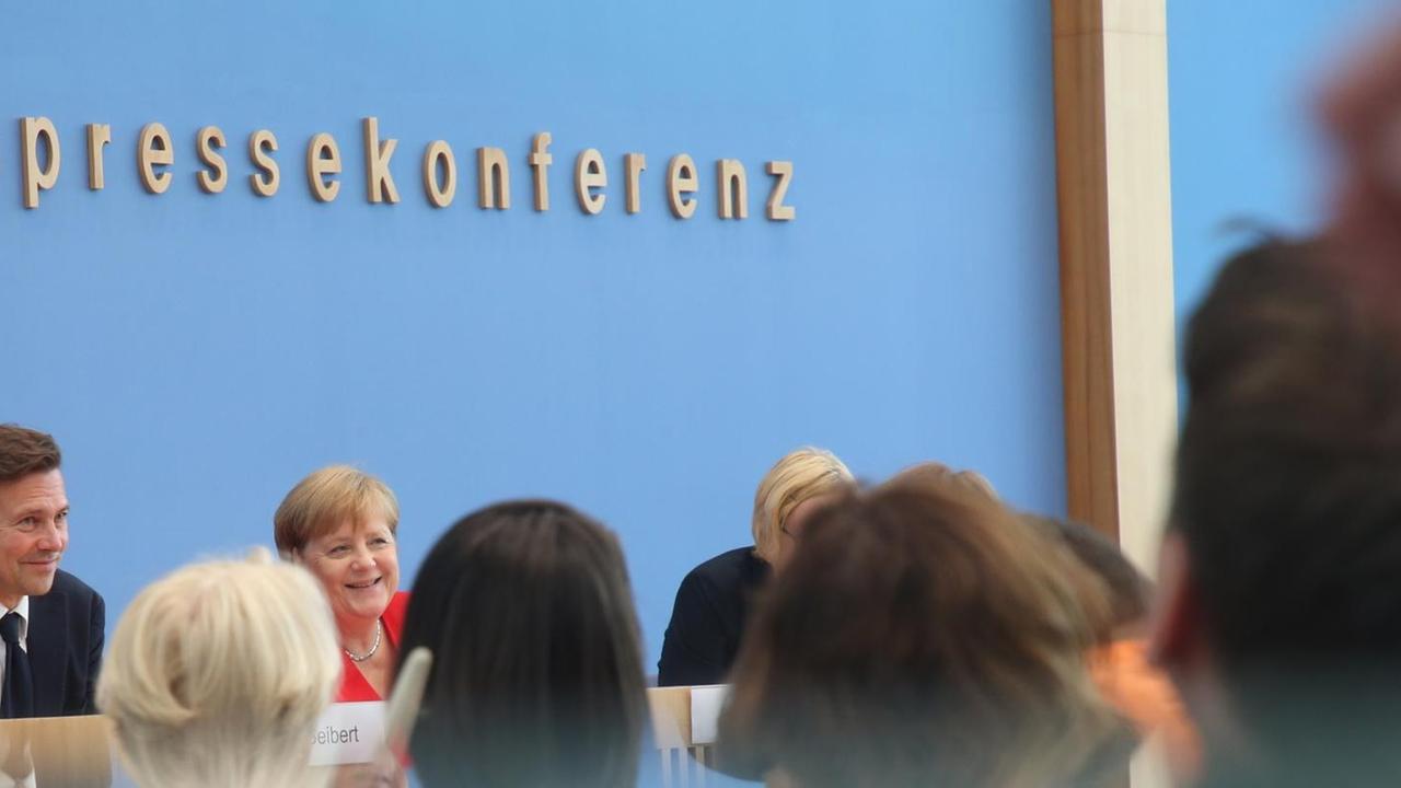 Bundeskanzlerin Angela Merkel (CDU - M) spricht am 19.07.2019 in der Pressekonferenz neben Corinna Buschow, Mitglied im Vorstand der Bundespressekonferenz, und Regierungssprecher Steffen Seibert