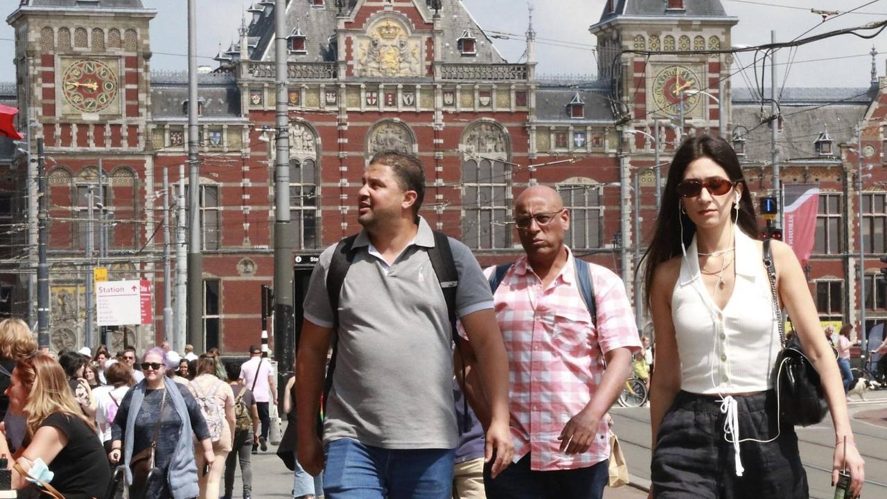 Das Foto zeigt Menschen in Amsterdam vor dem Hauptbahnhof im Juli 2021. Das Foto zeigt Menschen in Amsterdam vor dem Hauptbahnhof im Juli 2021.