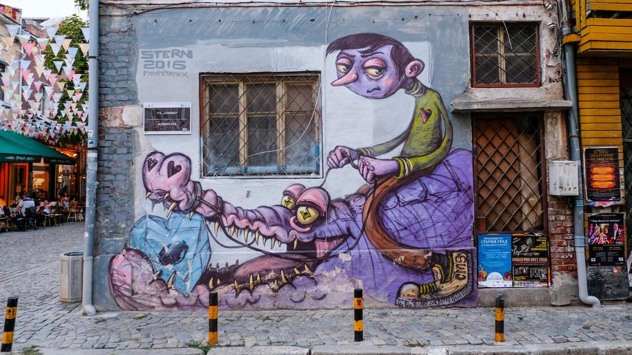 Grafitti im Restaurant- und Kneipenviertel Kapana in Plovdiv. Ein Junge sitzt auf einem Krokodil, das einen Diamanten im Maul hat.