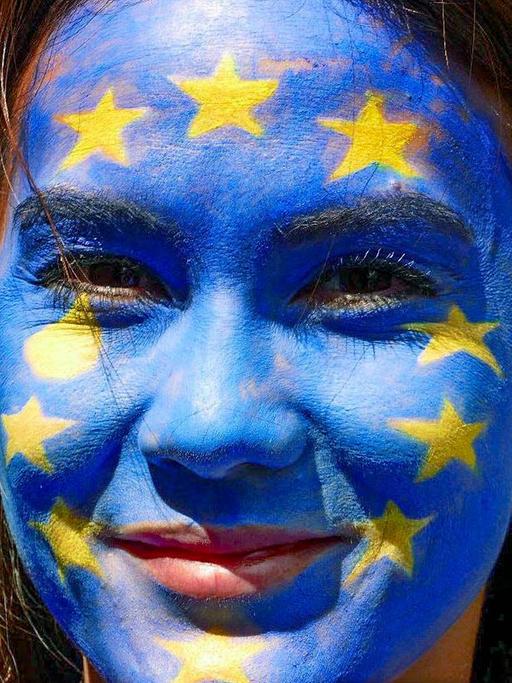 Eine Frau trägt die EU-Flagge im Gesicht.