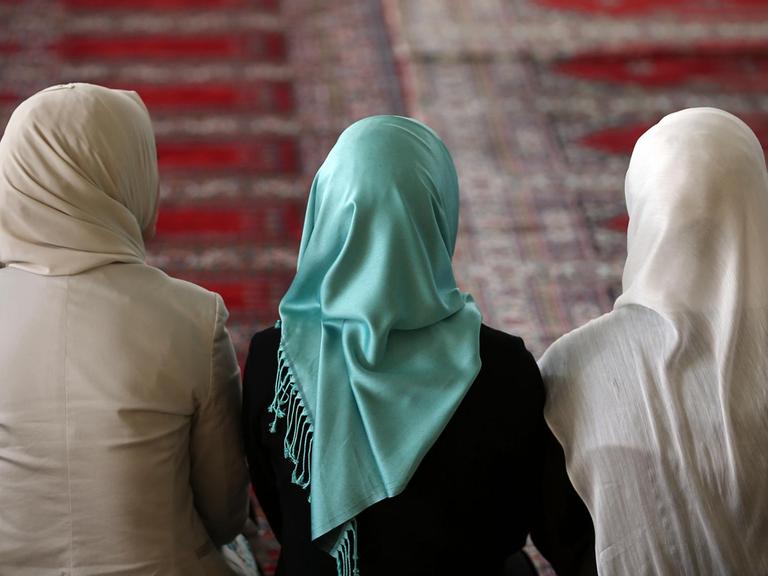 Muslimische Frauen sitzen in Köln (Nordrhein-Westfalen) in der Moschee mit Kopftüchern auf dem Gebetsteppich.