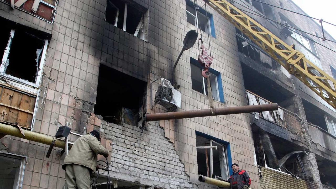 Arbeiter reparieren ein Dach in Donezk nach nächtlichem Beschuss (07.11.2014).