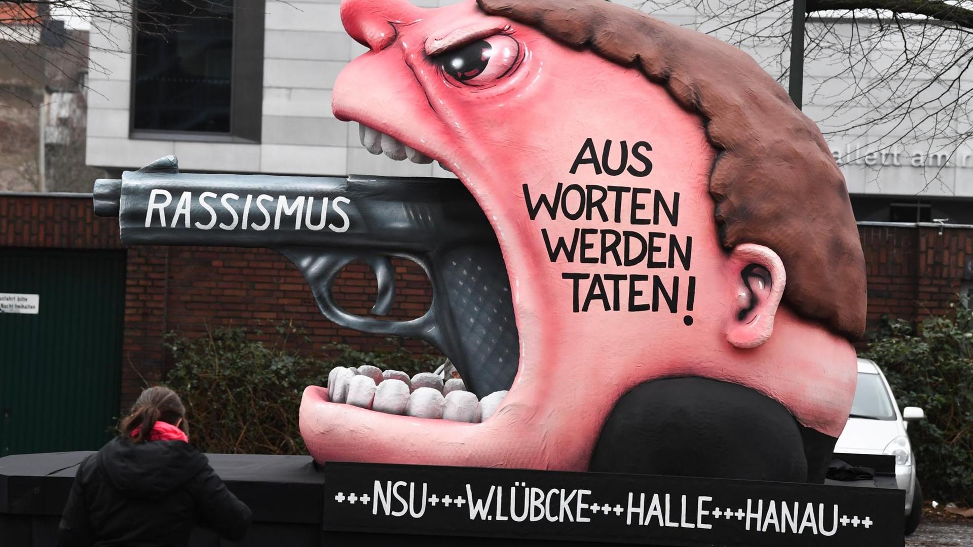 Ein Motivwagen "Rassismus - Aus Worten werden Taten! +++ NSU +++ W. Lübcke +++ Halle +++ Hanau" steht vor dem Rosenmontagszug auf der Straße. Ein Motivwagen "Rassismus - Aus Worten werden Taten! +++ NSU +++ W. Lübcke +++ Halle +++ Hanau" steht vor dem Rosenmontagszug auf der Straße.