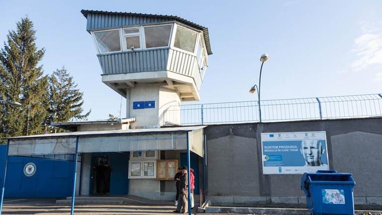 Eingang der rumänischen Haftanstalt Colibasi. Auf dem Plakat neben dem Eingang steht übersetzt: Wir sind das Produkt der Umwelt, in der wir leben. Es wird damit für eine bessere Integration von entlassenen Häftlingen geworben.