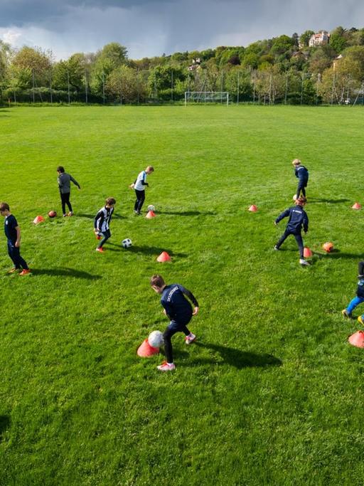 Fußballer der Altersklasse U-10 vom SV Loschwitz trainieren auf dem Spielfeld in großen Abständen.
