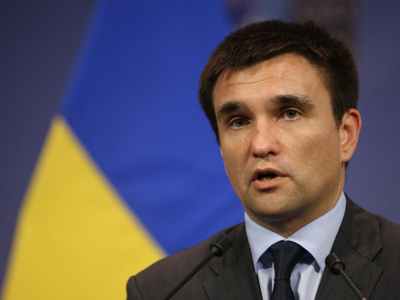 Der ukrainische Außenminster Pawel Klimkin, sprechend, eine gelb-blaue Fahne im Hintergrund.