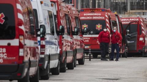 Rote Krankenwagen warten in Portugal vor einem Krankenhaus in einer Schlange.