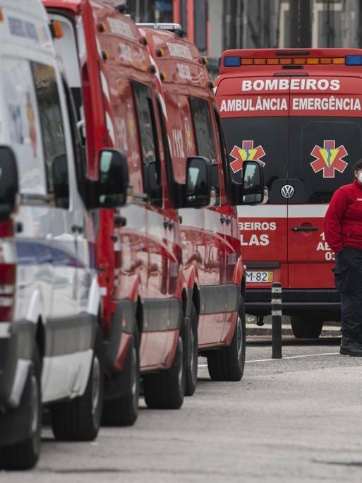 Rote Krankenwagen warten in Portugal vor einem Krankenhaus in einer Schlange.