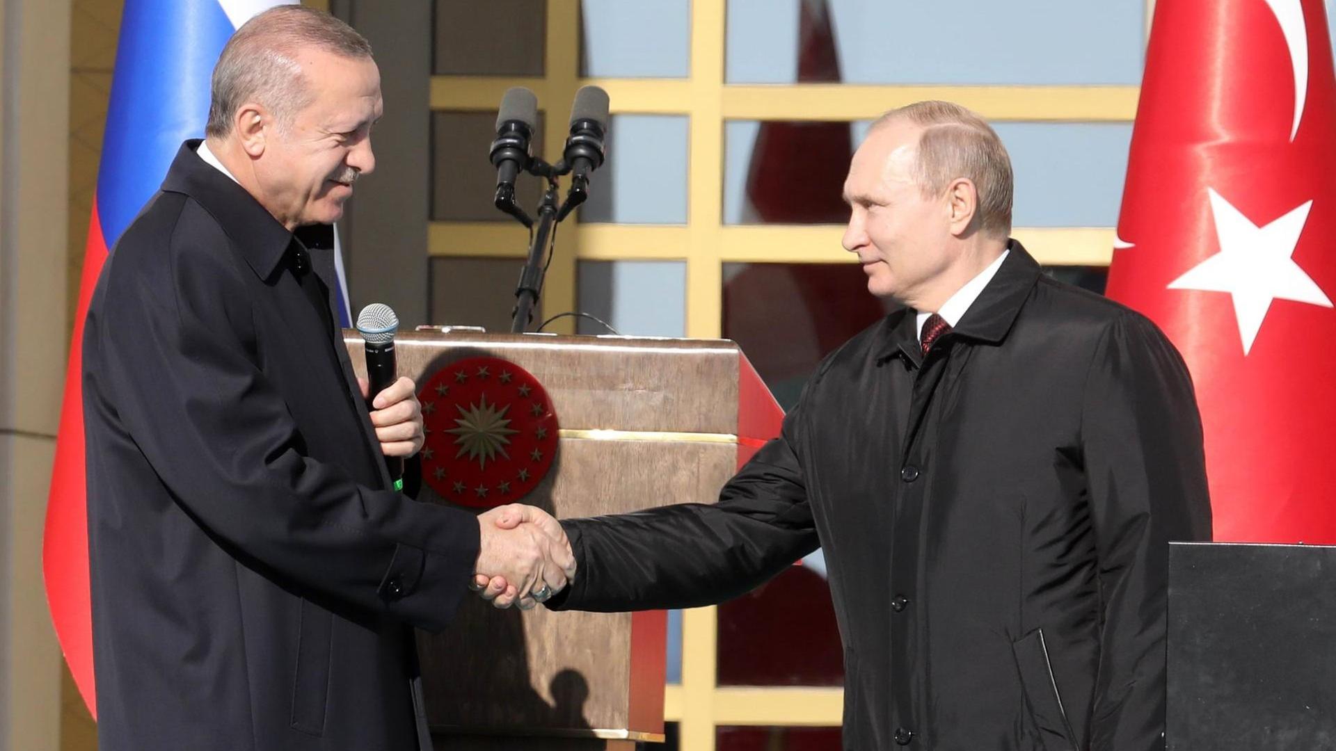 Der türkische Präsident Recep Tayyip Erdogan und Russlands Präsident Wladimir Putin schütteln sich die Hände bei der Auftaktzeremonie für den Bau des ersten Atomkraftwerks auf türkischem Boden, das mit Moskaus Hilfe entsteht