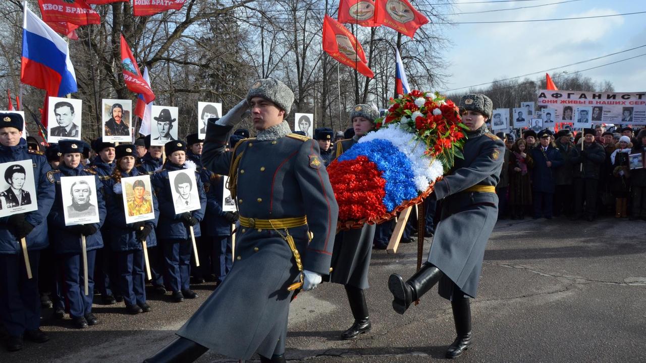 Zu sehen ist auf dem Foto das "Unsterbliche Regiment": Veteranen und Angehörige halten bei Gedenkmarsch Schilder mit Porträts getöteter sowjetischer Soldaten hoch.