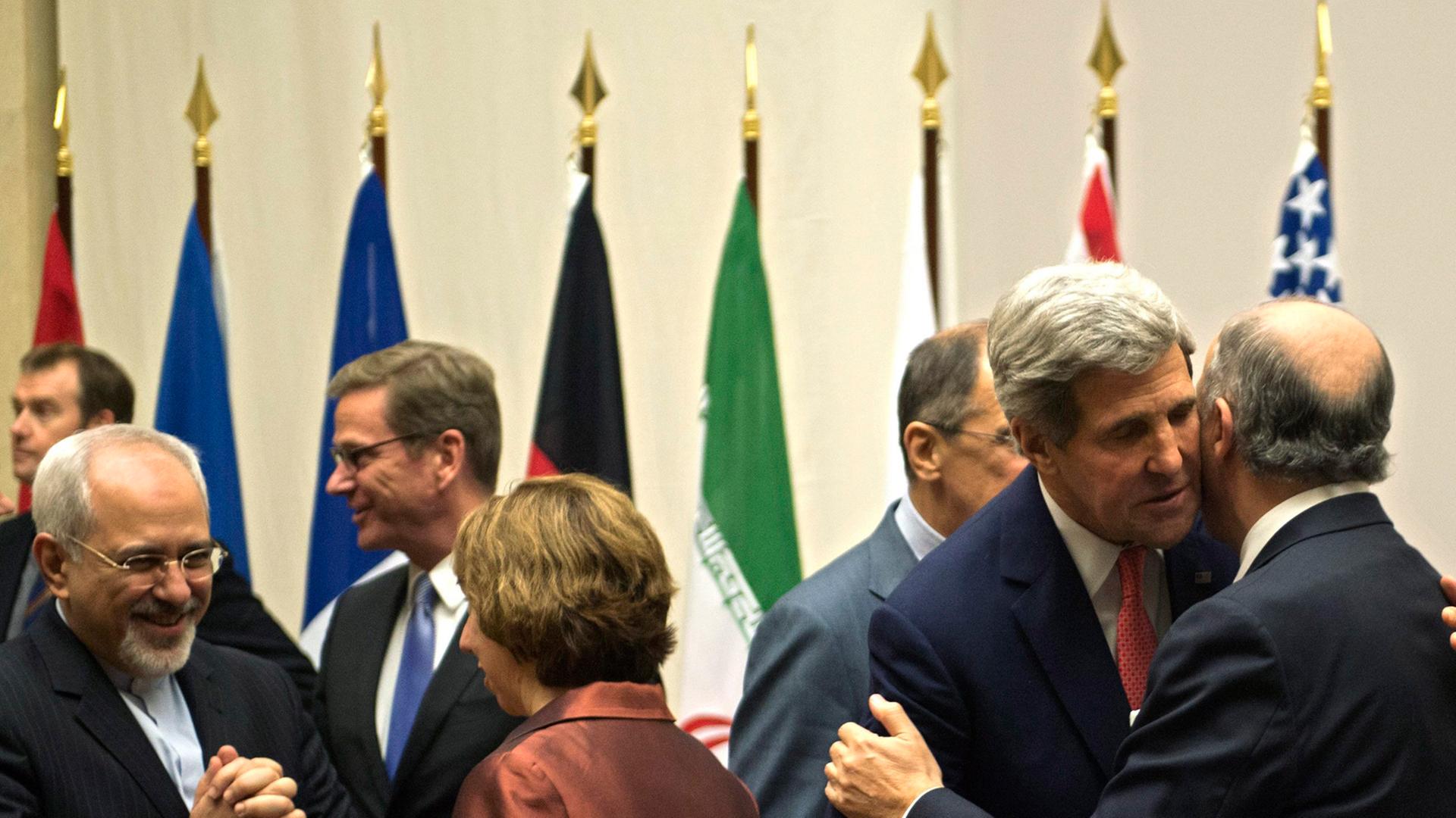 EU-Außenbeauftragte Catherine Asthon (2. von links, 1. Reihe) spricht mit dem iranischen Außenminister Mohmammad-Javad Zariv (1. von links, 1. Reihe), während der US-Außenminister John Kerry (2. von rechts) den französischen Außenminister Laurent Fabius (1. von rechts) begrüßt.