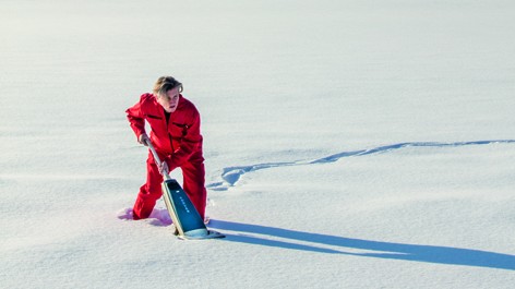 Ein Bild aus dem Buch "Putzen - eine Kulturtechnik" von Sonnja Stummerer und Martin Hablesreiter.Der Performance Künstler Martin Hablesreiter mit einem Staubsauger im tiefen unberührten Schnee. Böhlau Verlag, 2020.