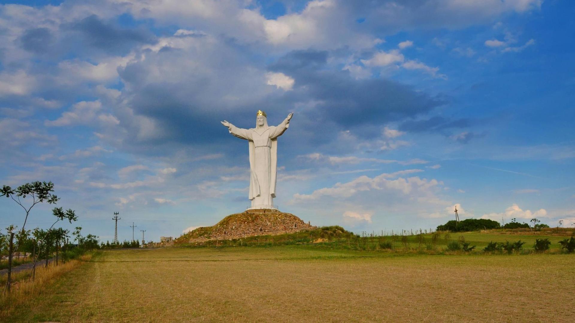 Die golden gekrönte Christusstatue, erbaut in der Stadt Swiebodzin in Woiwodschaft Lubusz im Jahr 2010, gilt als die höchste Jesusstatue der Welt gilt. Um sie herum sind Felder zu sehen.