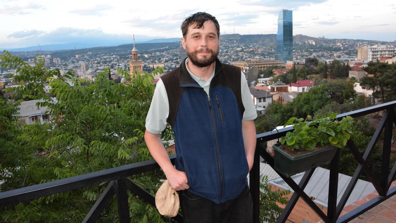Schrifsteller Abo Iaschaghaschwili steht auf einer Beobachtungsplattform mit Blick auf Tiflis.