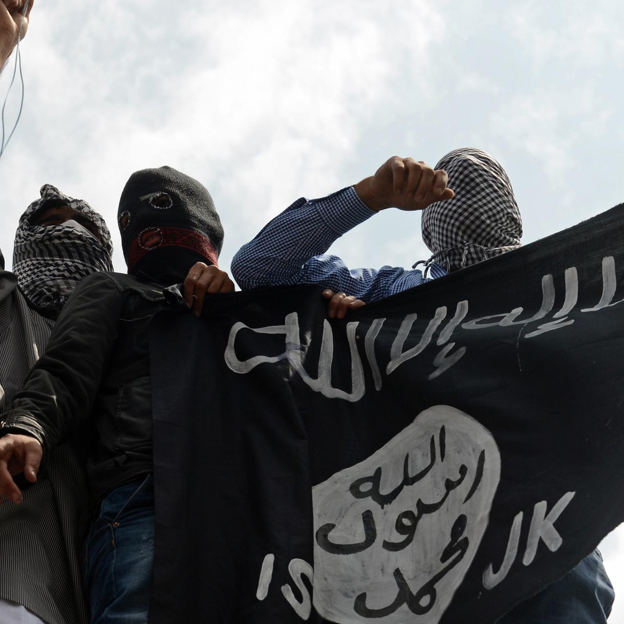 Unterstützer der Extremistenmiliz Islamischer Staat (IS) mit Fahne.