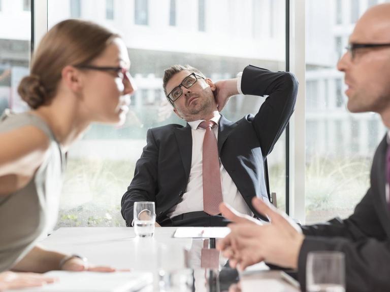 Drei Menschen in Arbeitskleidung streiten.