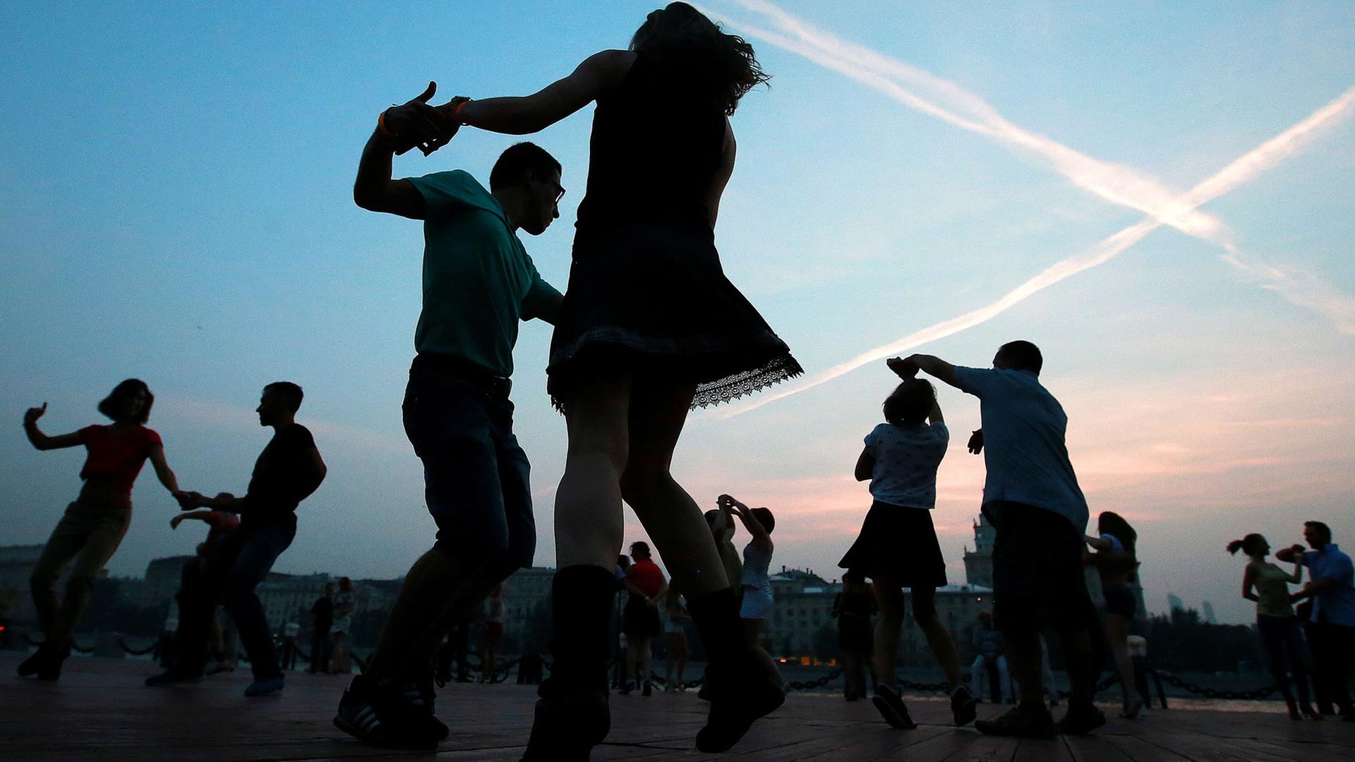 Paare tanzen bei Sonnenuntergang im Gorky Park in Moskau.