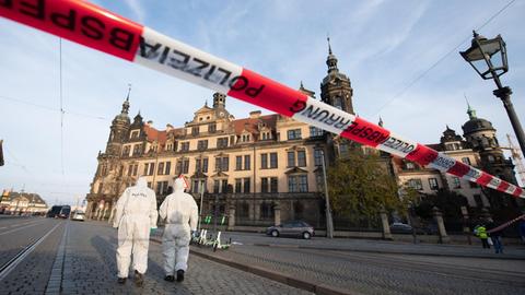 Zwei Mitarbeiter der Spurensicherung vor dem Residenzschloss mit dem Grünen Gewölbe hinter einem Absperrband