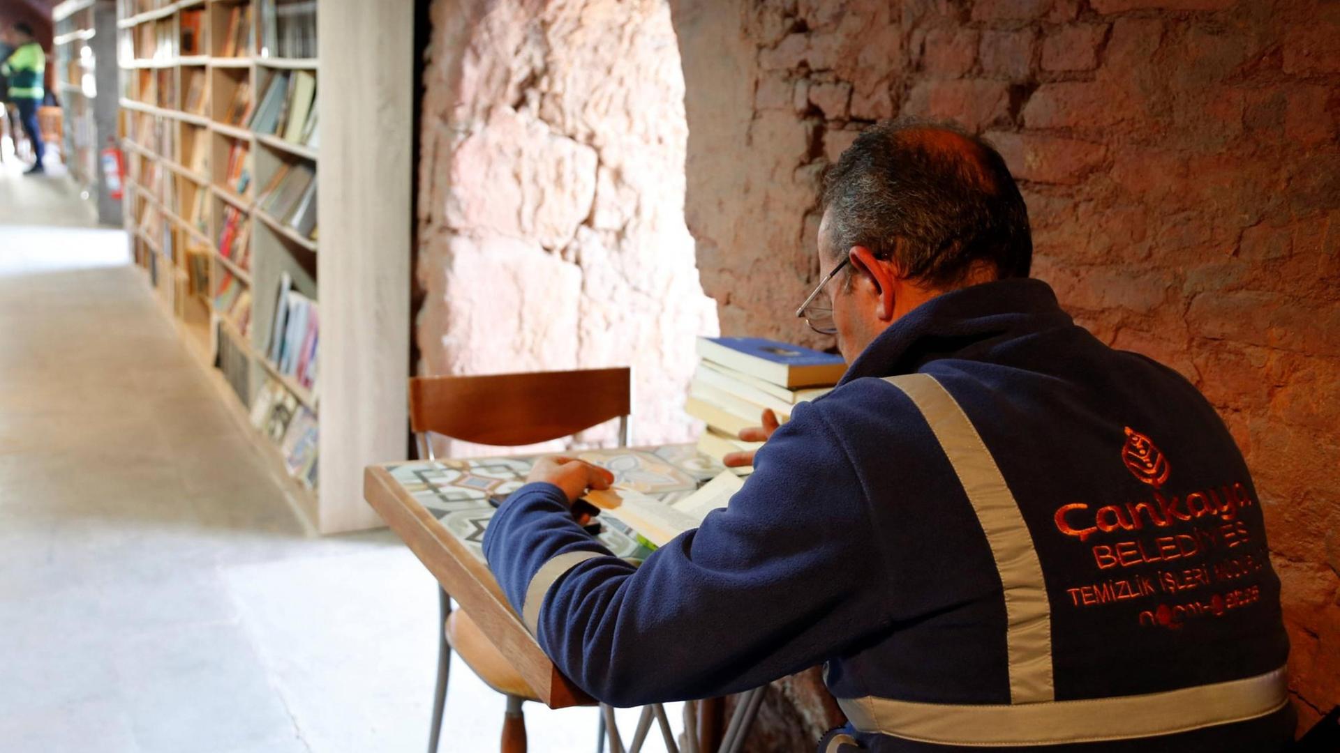 Ein Arbeiter sitzt in der Bücherei der Müllmänner von Ankara, die in einer ehemaligen Ziegelsteinfabrik im Stadtteil Cankaya eingerichtet wurde, und liest