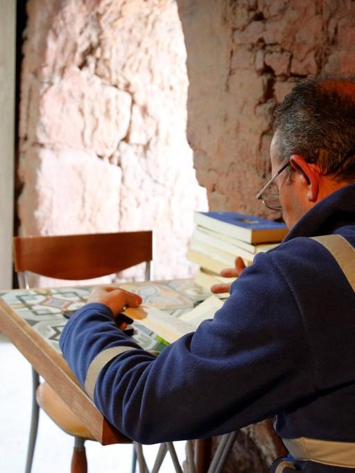 Ein Arbeiter sitzt in der Bücherei der Müllmänner von Ankara, die in einer ehemaligen Ziegelsteinfabrik im Stadtteil Cankaya eingerichtet wurde, und liest