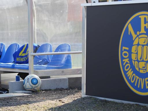 Die Auswechselbank und das Logo von Lokomotive Leipzig im Bruno-Plache-Stadion